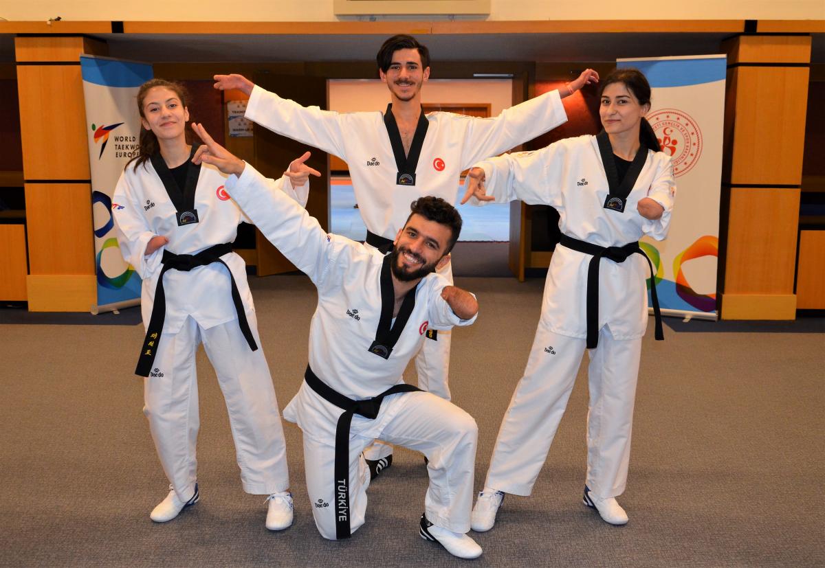 a group of Turkish taekwondo fighters posing for the camera