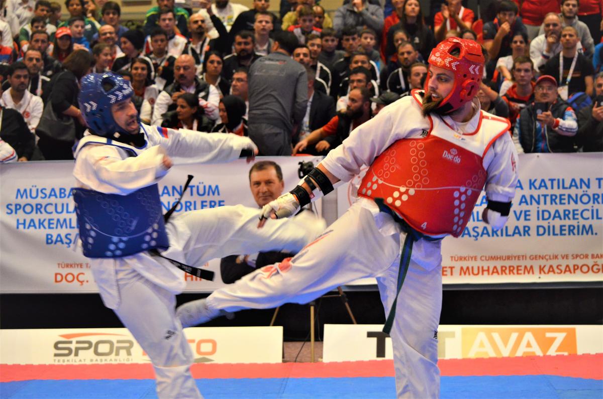 male Para taekwondo fighter Matt Bush kicks another fighter around the legs