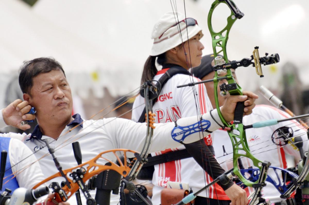 male Para archer Ouk-Soo Lee draws back his bow and prepares to shoot