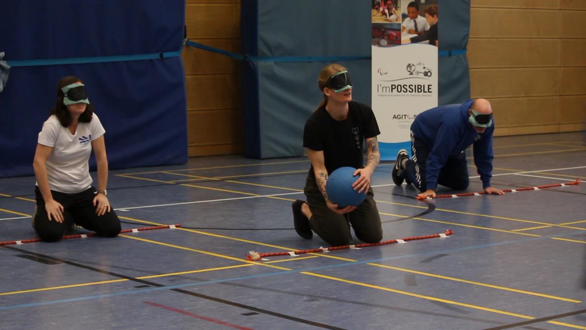 teachers with eyeshades play goalball in sport hall of the Bonn International School