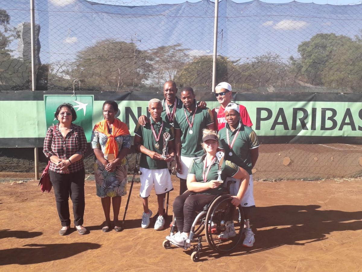 male and female wheelchair tennis players from South Africa hold up a trophy and smile