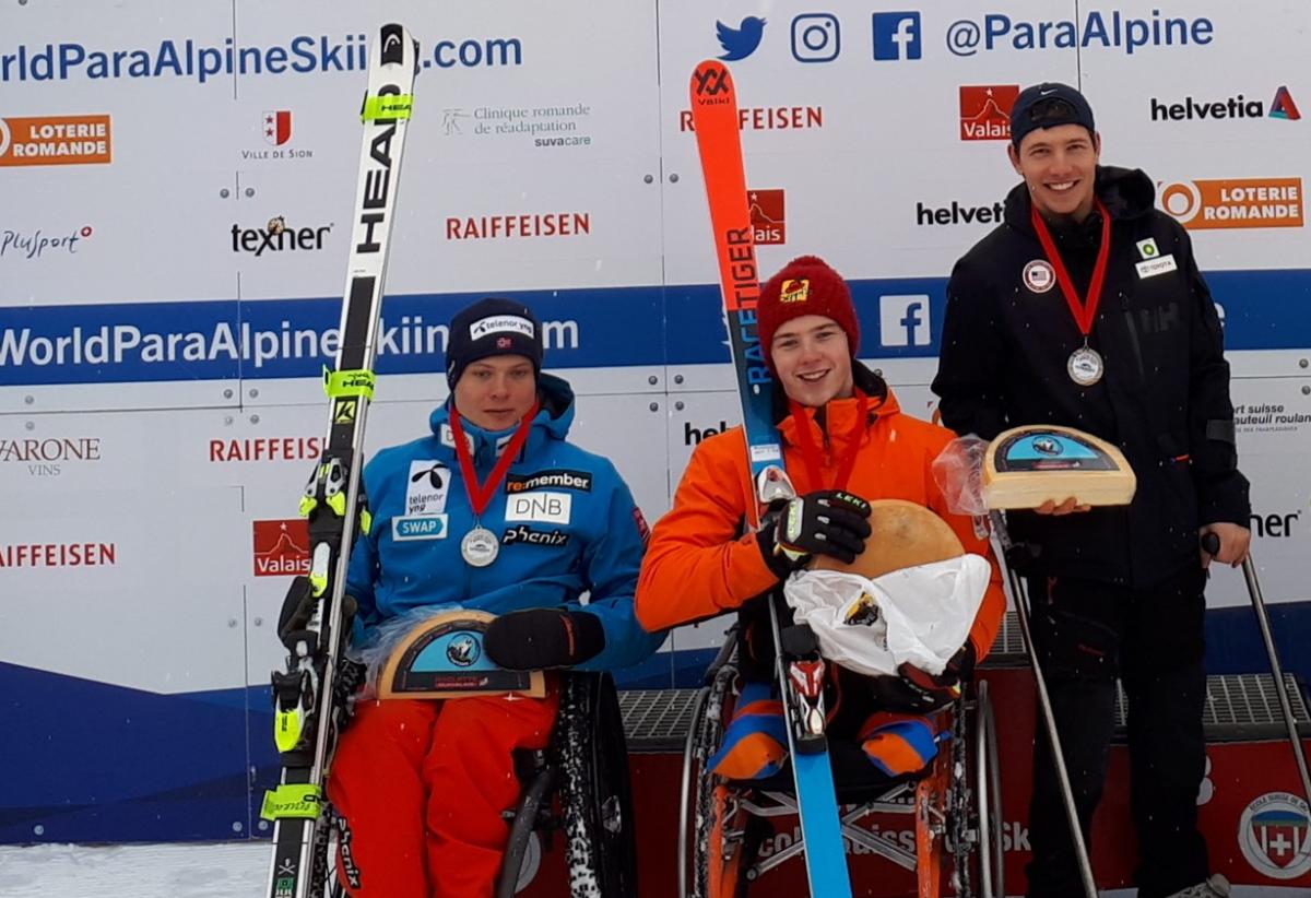 Veysonnaz cheese winners three Para alpine skiers holding up wheels of cheese on the podium