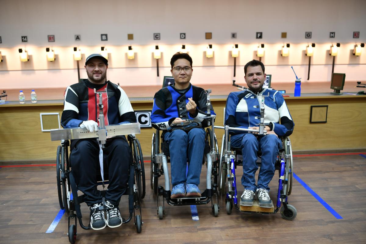 Three male shooters in wheelchairs