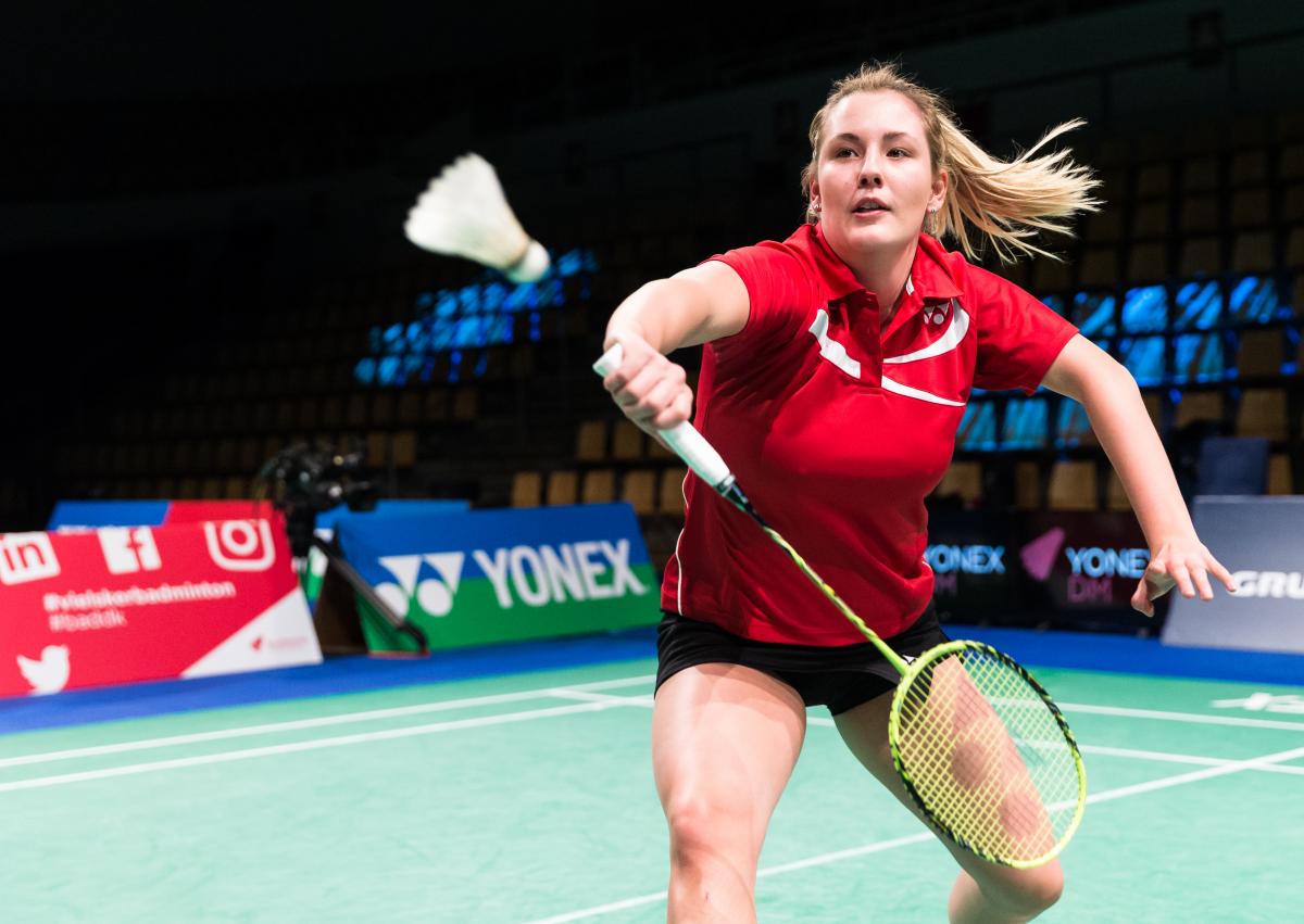 female Para badminton player Cathrine Rosengren reaches to play a backhand