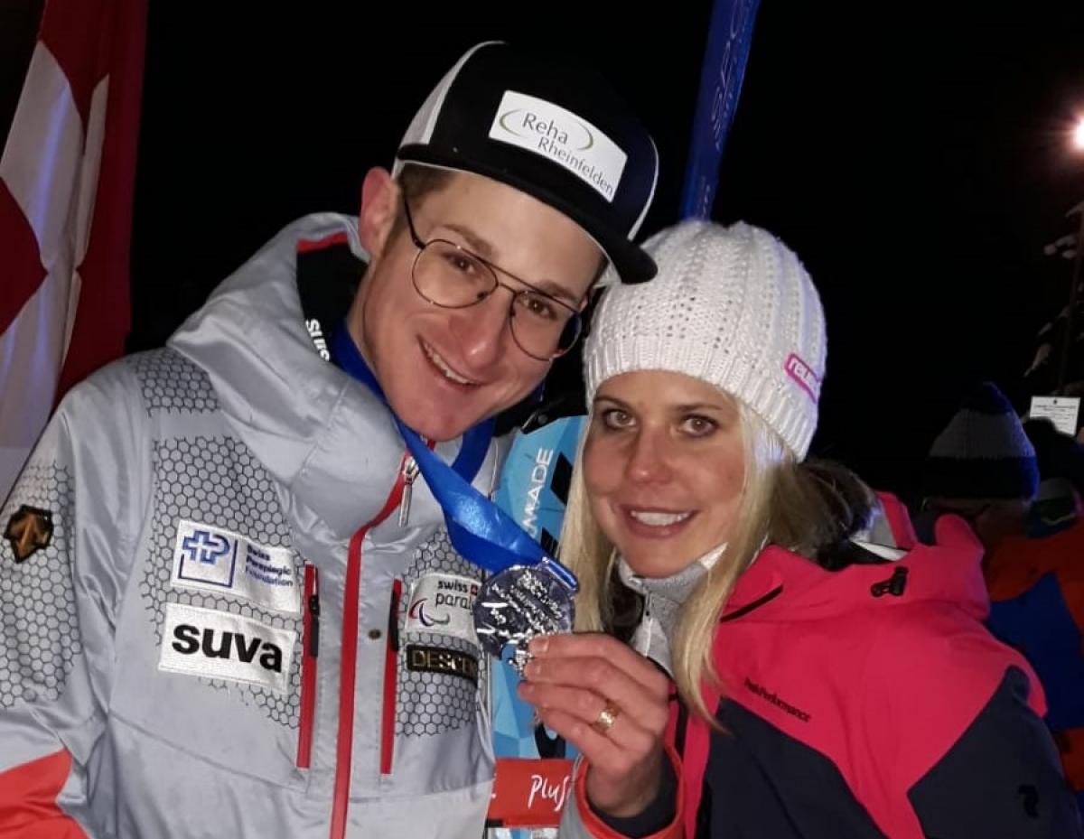 male Para alpine skier Thomas Pfyl hugs his wife Evelyn while both smile