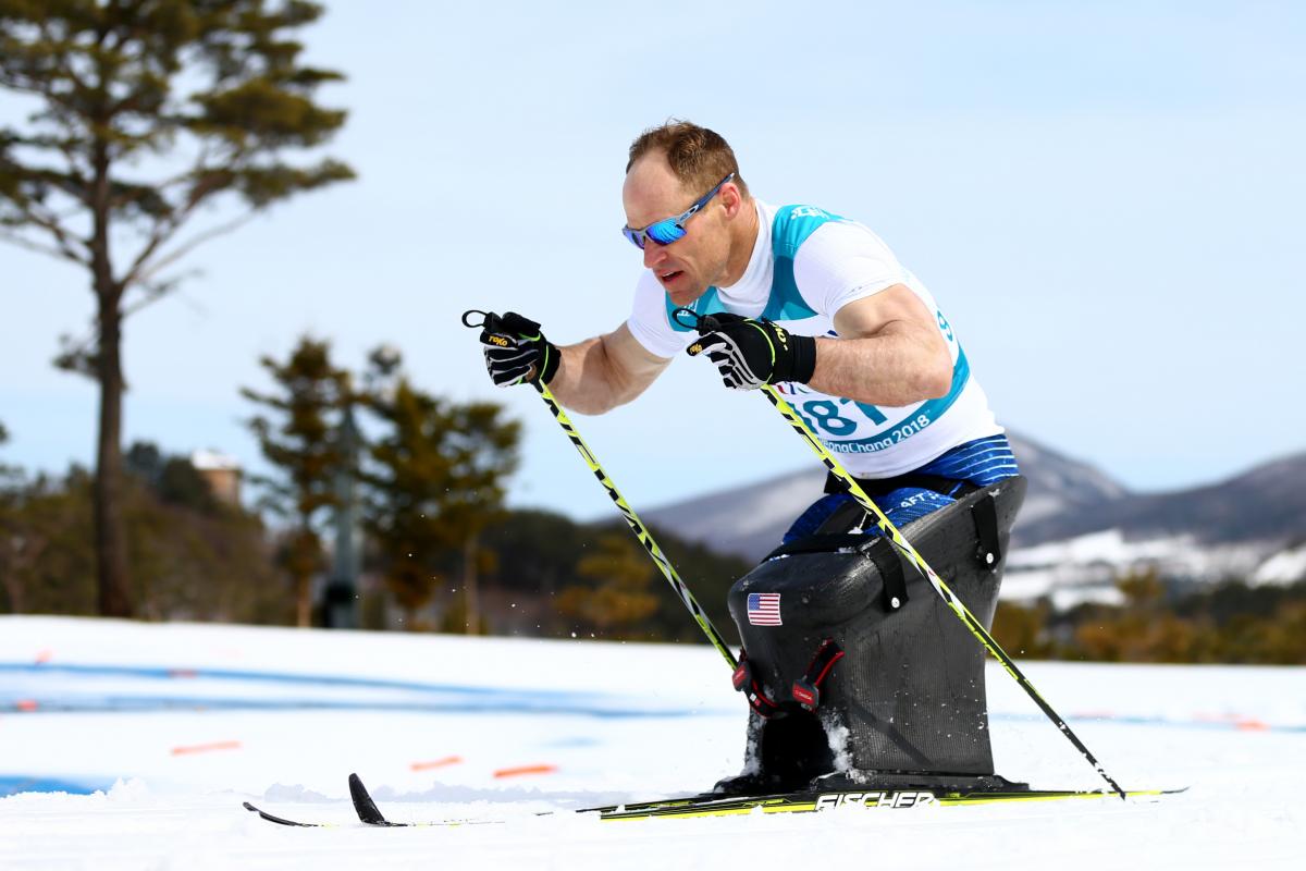male Para Nordic sit skier Daniel Cnossen pushes through the snow