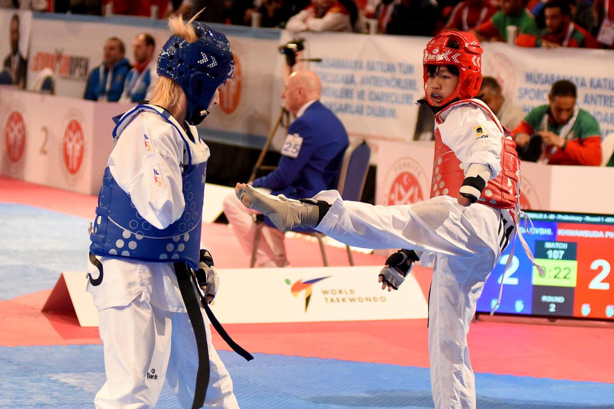 female Para taekwondo fighter Khwandusa Phuangkitcha kicks out towards another fighter