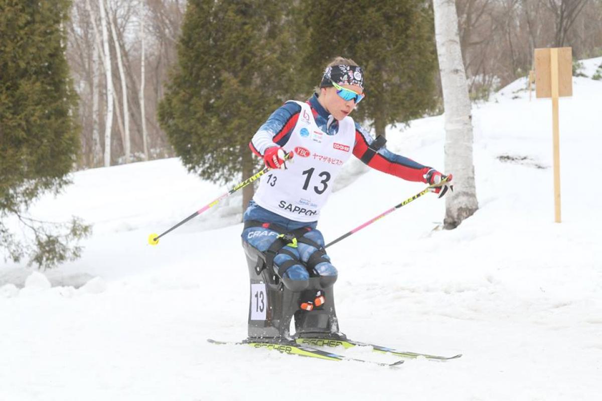 female Para Nordic sit skier Oksana Masters turns round a bend in the course