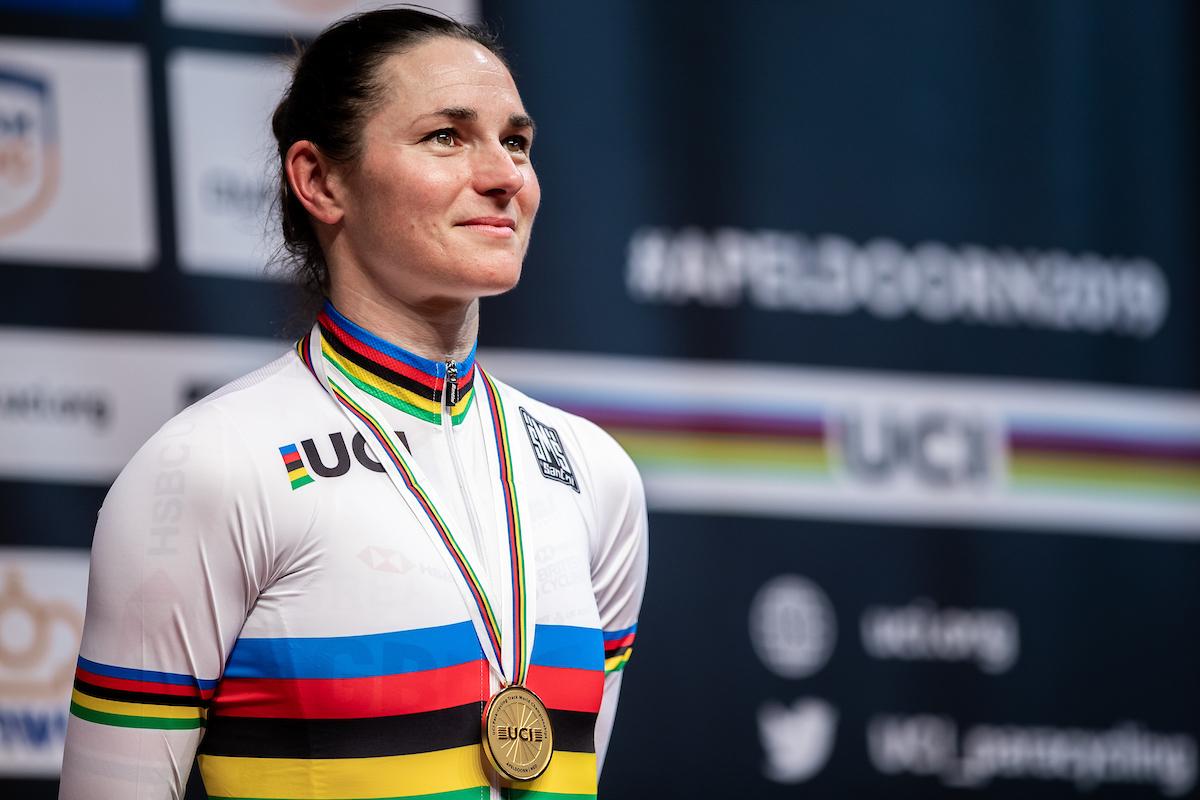 female Para cyclist Sarah Storey stands on the podium with a gold medal around her neck