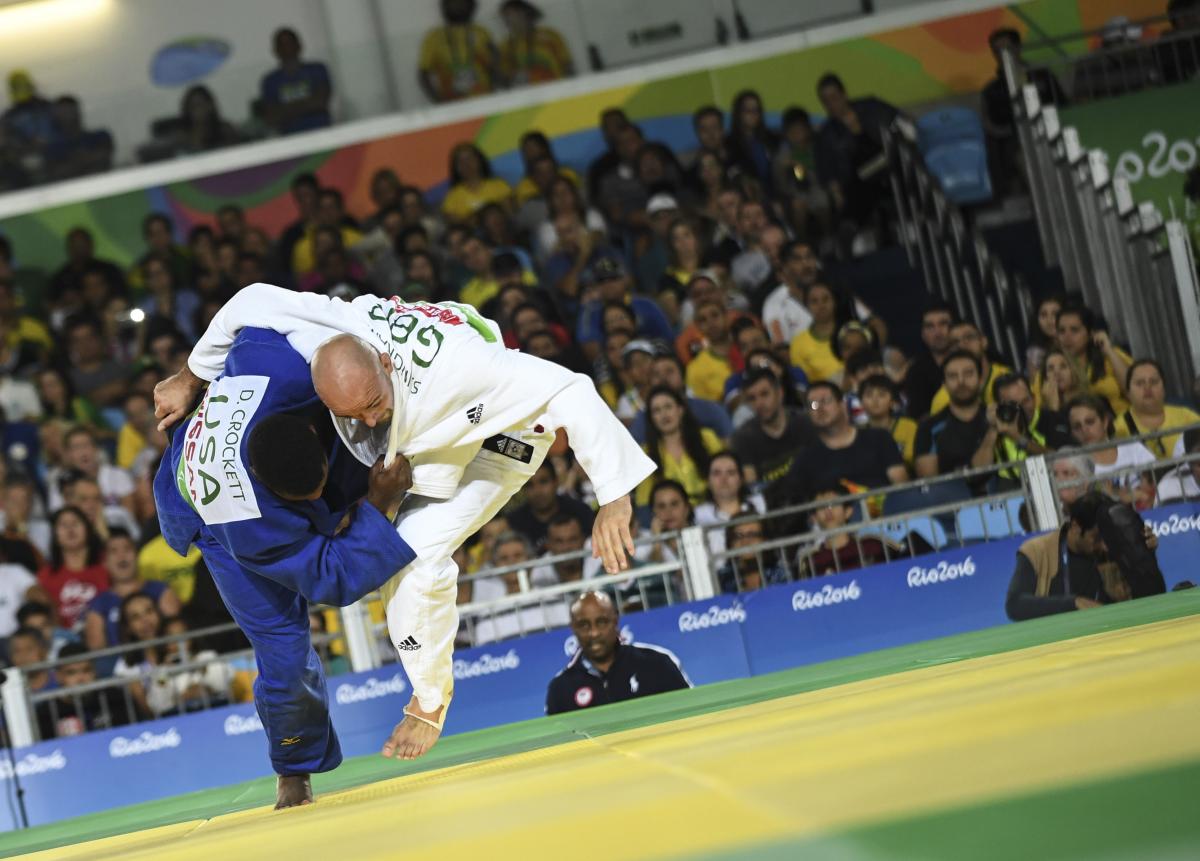 male Para judoka Sam Ingram throws another judoka onto the mat