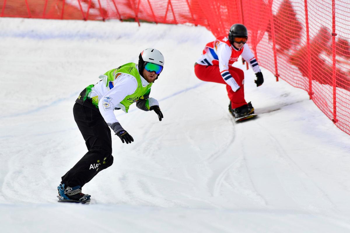 Simon Patmore - La Molina two male Para snowboarders racing down the slope head to head