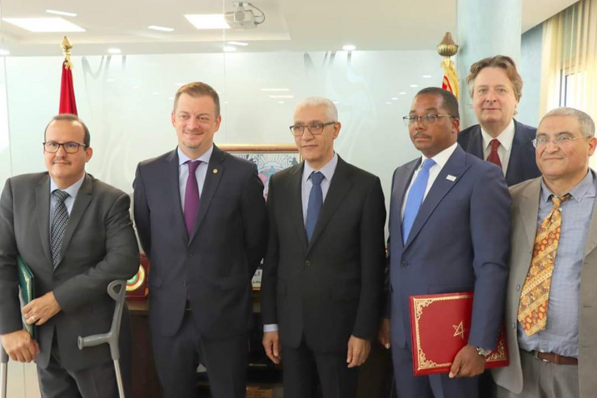 six men including IPC President Andrew Parsons standing side by side in an office