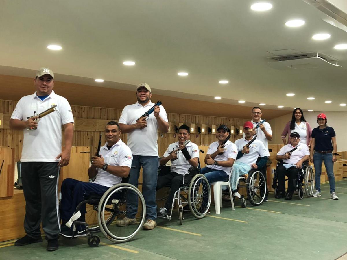 a group of male and female Para shooters from Colombia next to the target range