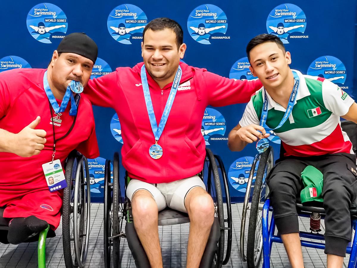Three men in wheelchairs in a podium