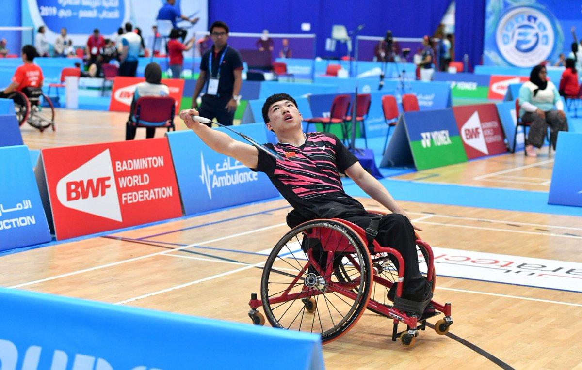 male Para badminton player Qu Zimao goes for a backhand shot on court