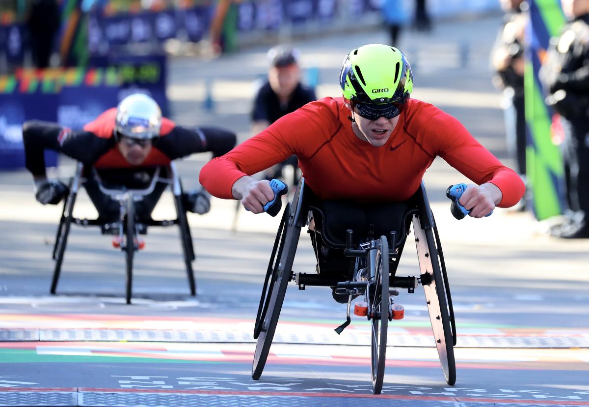 marathon racer Daniel Romanchuk crosses the finish line to win