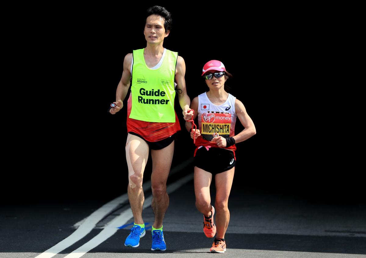Misato Michishita - 2018 London Marathon female vision impaired runner Misato Michishita running on the street with a male guide