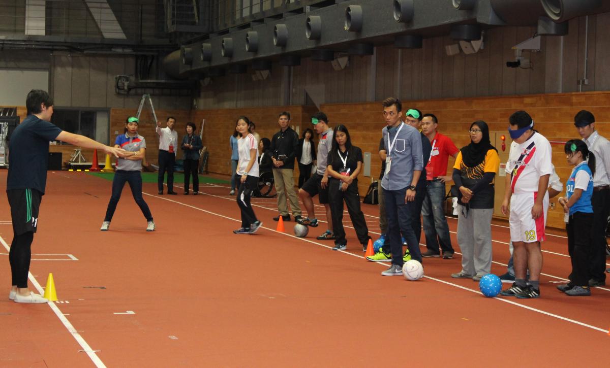 A group of people standing on a court blindfolded