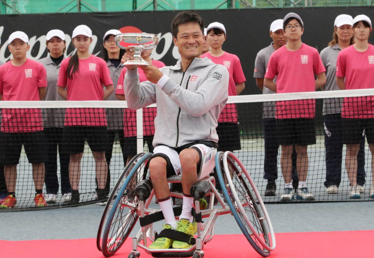 male wheelchair tennis player Shingo Kunieda smiling and holding up a silver trophy