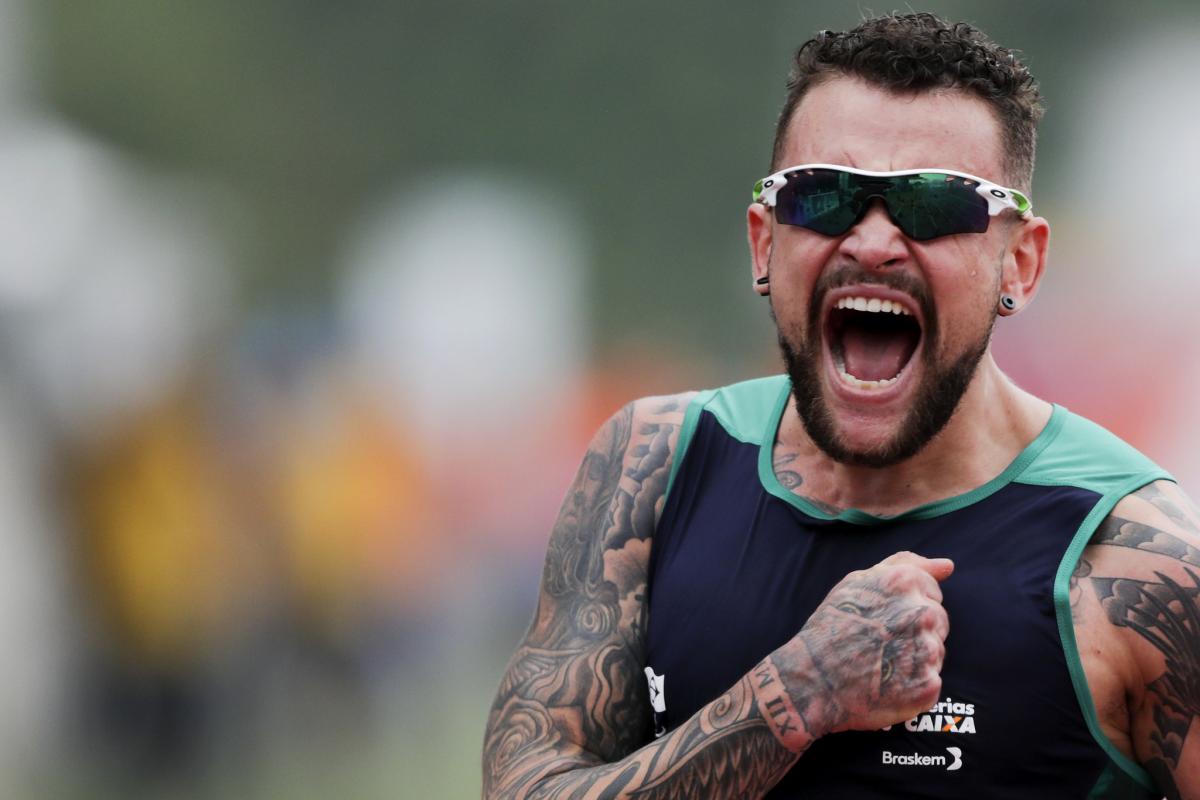 male Para athlete Vinicius Rodrigues beats his chest and screams in celebration