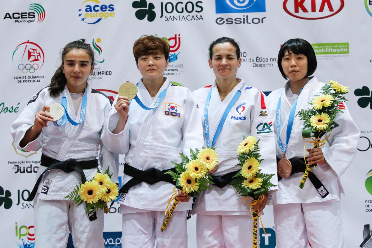 female judoka Sandrine Martinet on the podium holding her medal