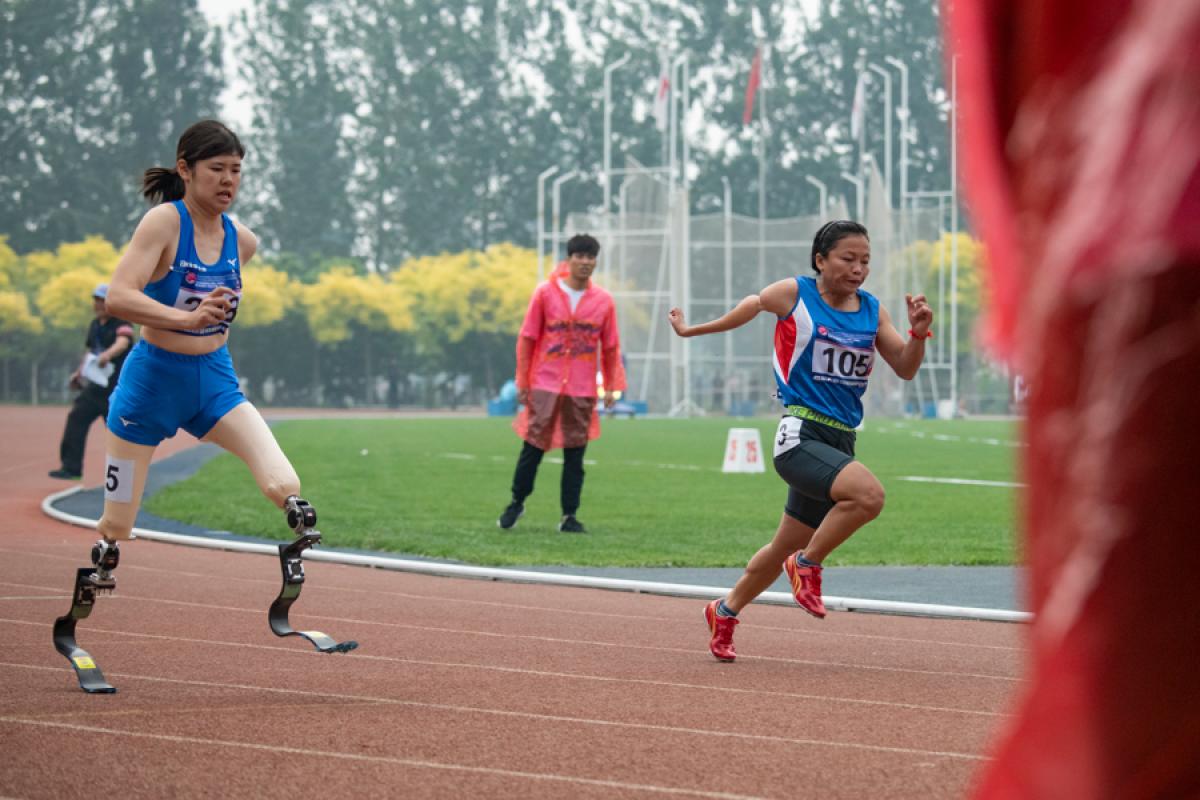 Erina Yuguchi - Japan - Beijing 2009 Para Athletics Grand Prix A double-leg amputee woman running against another woman on an athletics track
