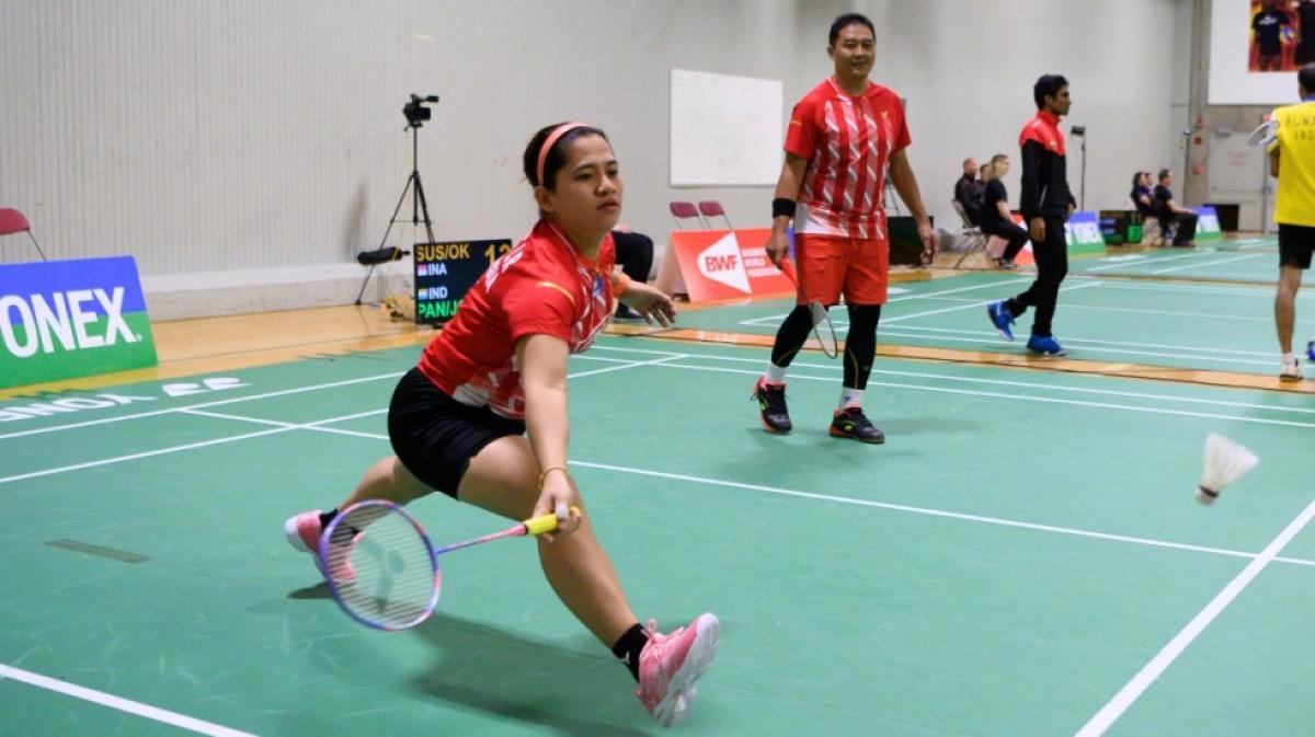 Indonesian female badminton player lunges for the birdie