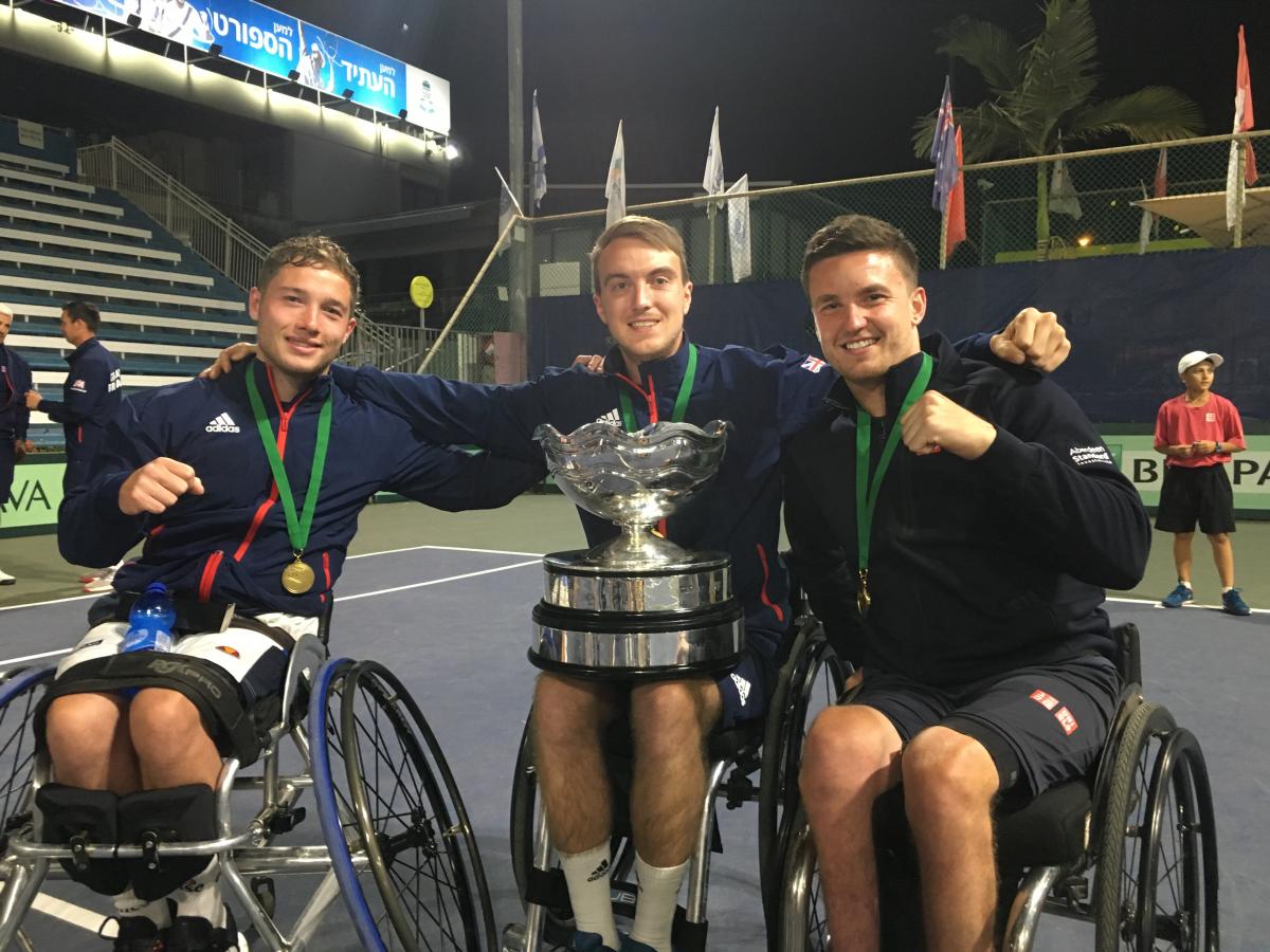 British players smile at the camera while showcasing the trophy