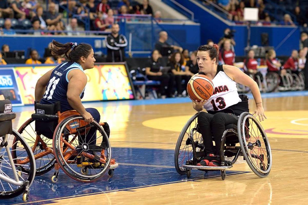 Canada - Argentina - wheelchair basketball Canadian wheelchair basketball player holds the ball as an Argentinian defender tries to prevent her from scoring