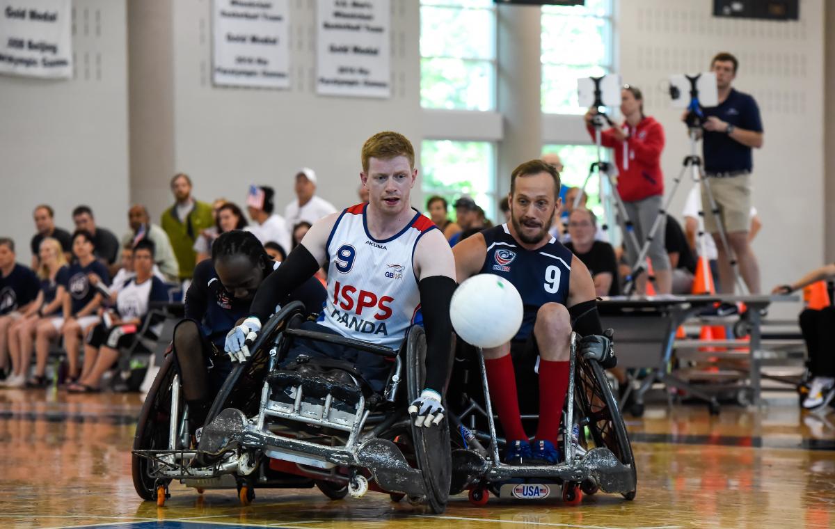 Two male wheelchair rugby players collide trying to fight for a loose ball
