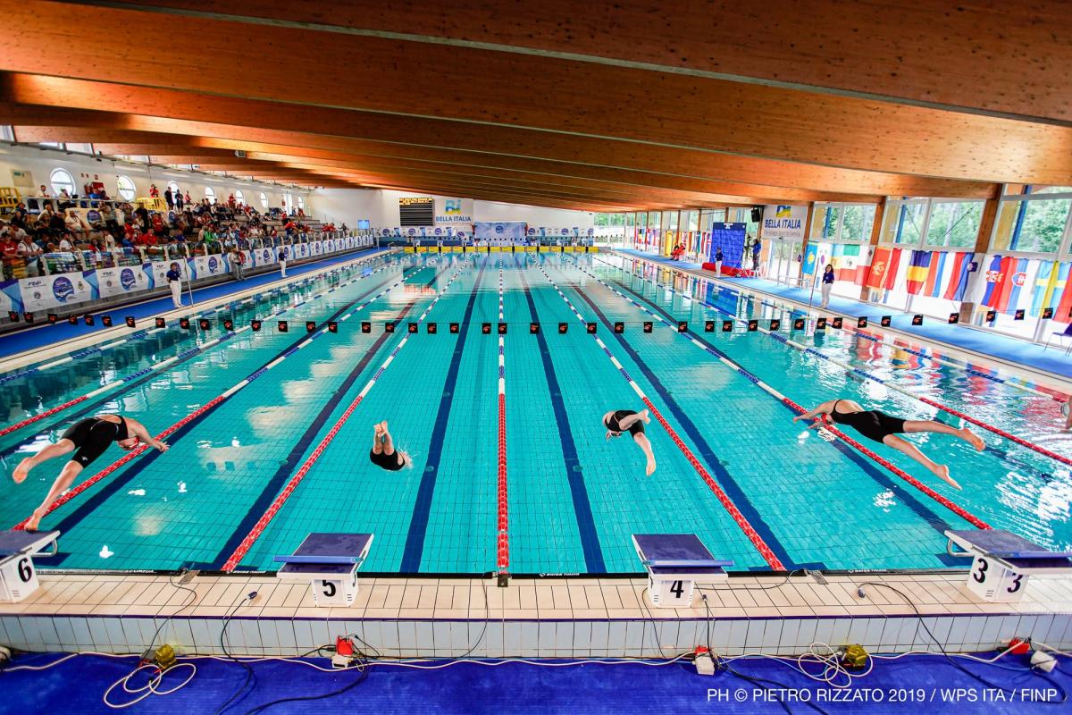 Four swimmer diving into the water to start the race