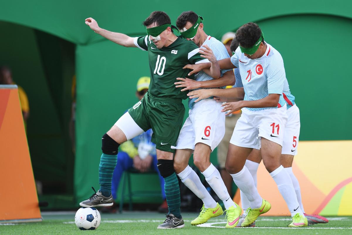 Ricardinho controls the ball, while two Turkish players try to take it from him