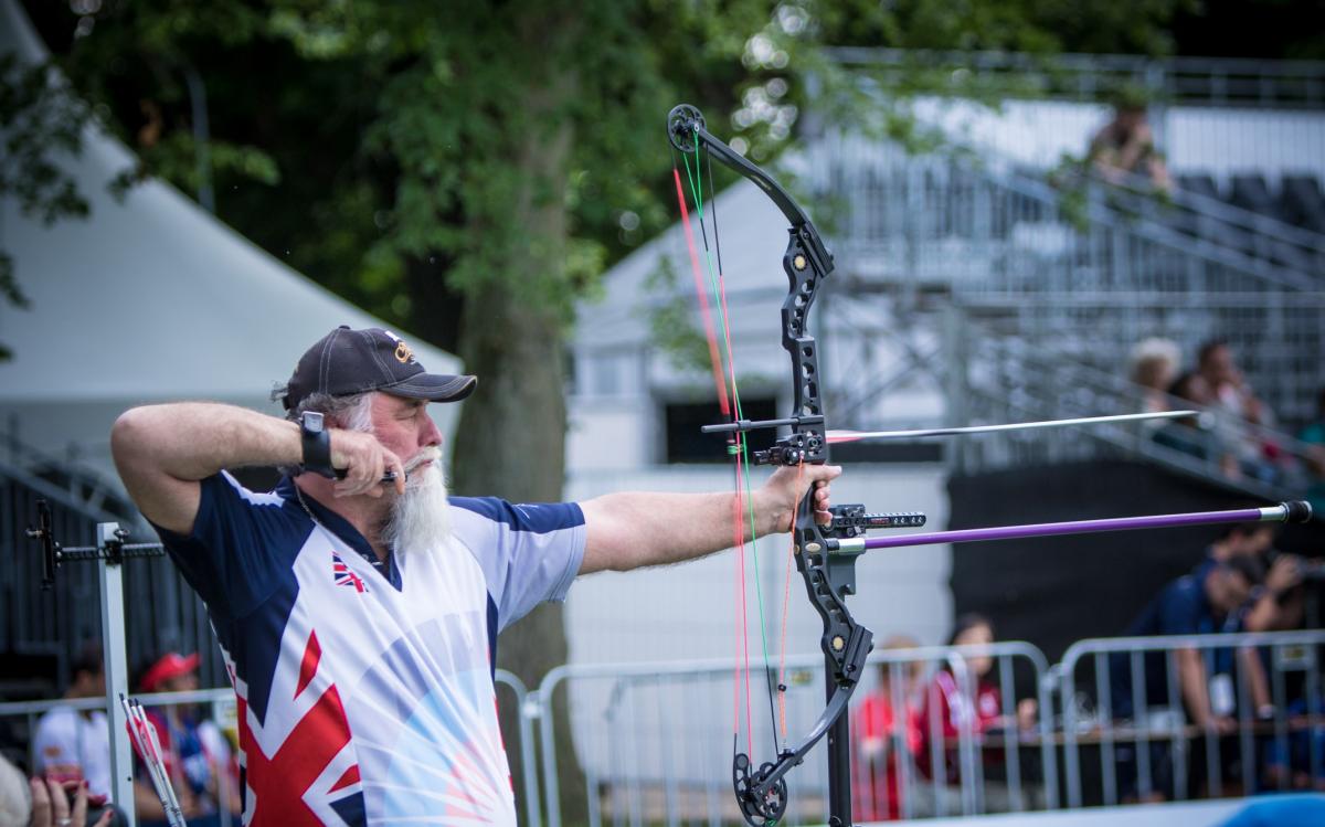 Steve Prowse - archery - Great Britain Man with long white beard shoots his bow and arrow