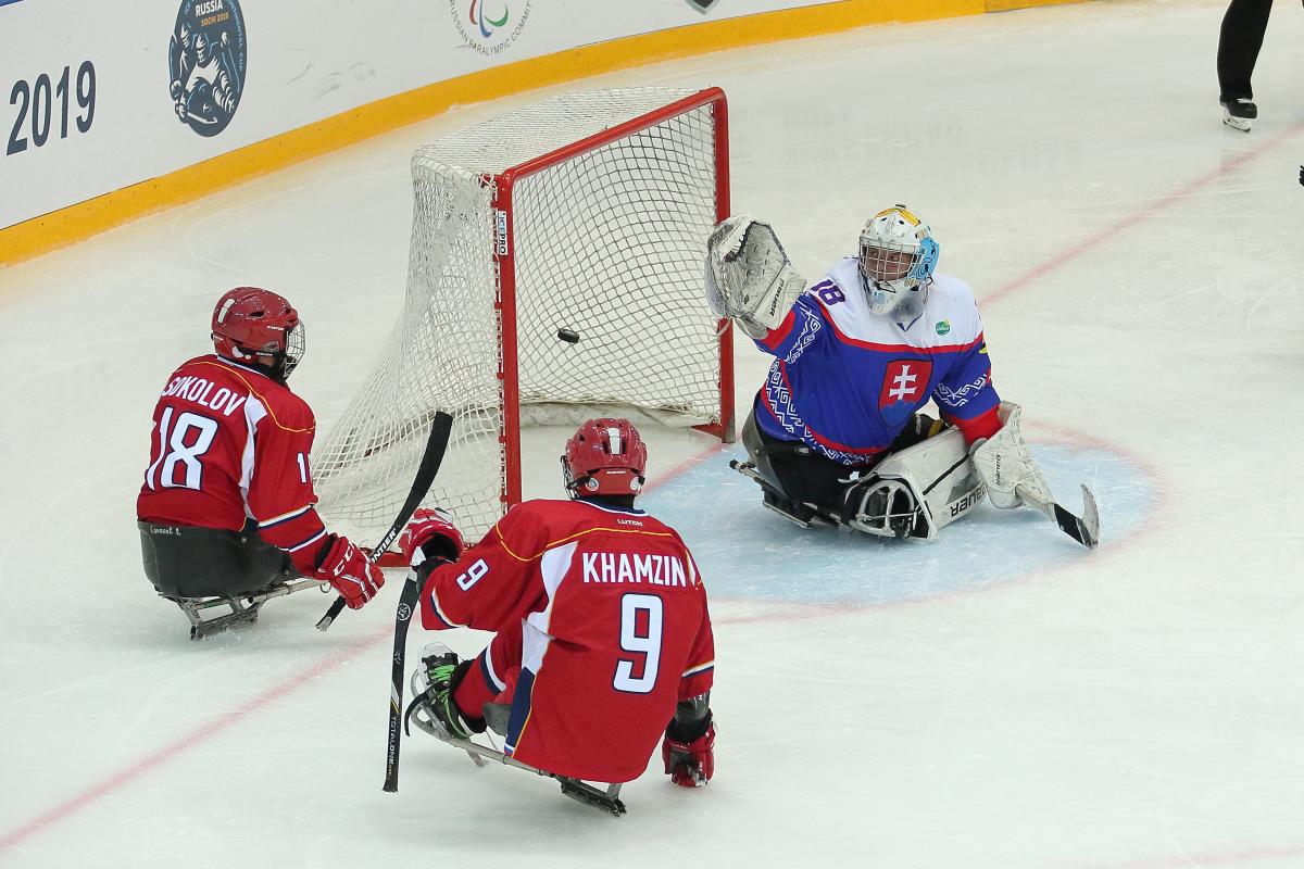 Two Russian Para ice hockey players in front the Slovakian goaltender