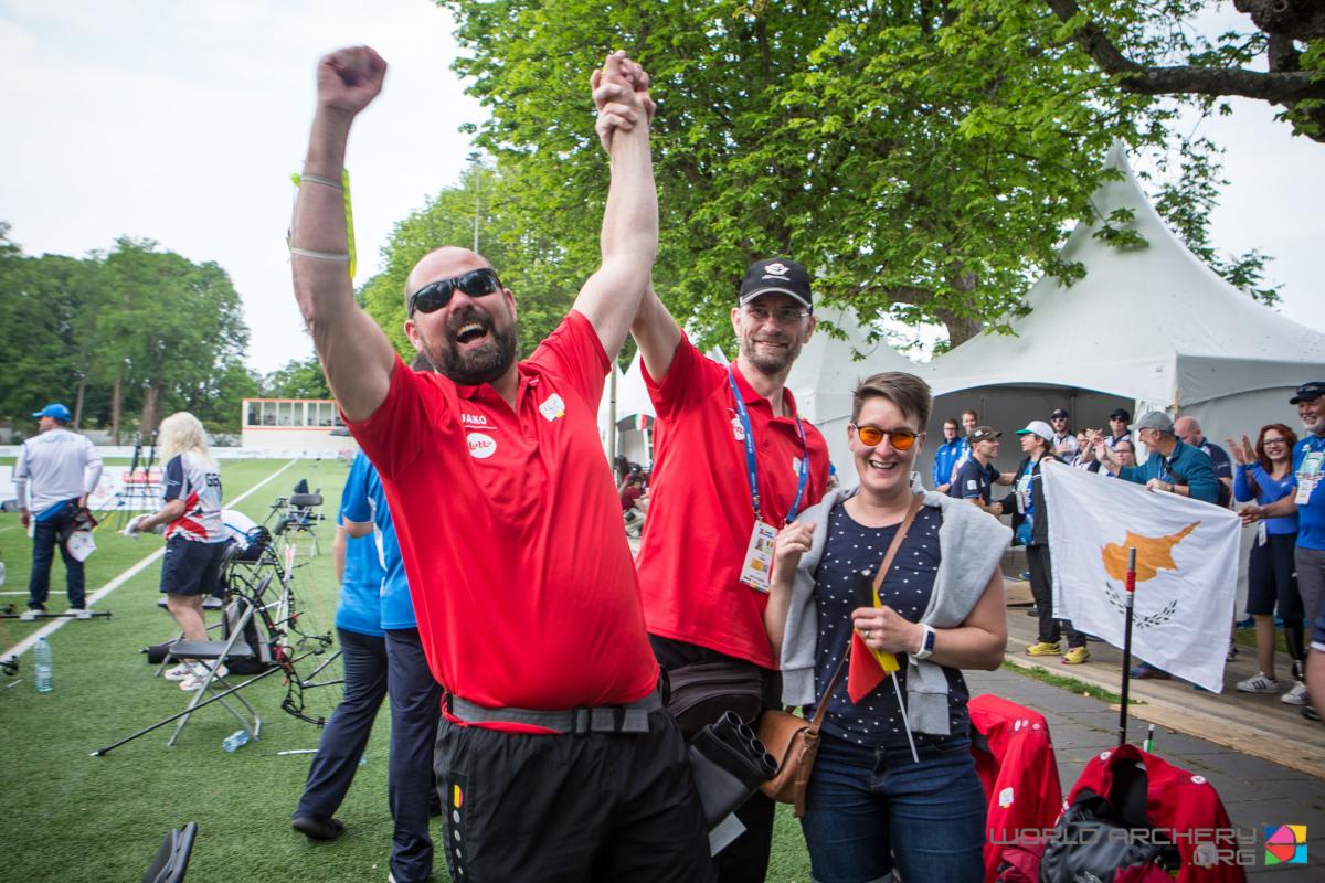 Vision impaired male archer celebrates with his coach hugging him