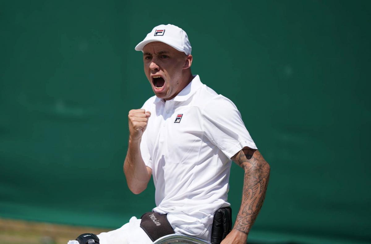 British male wheelchair tennis player clutches fist to celebrate a point