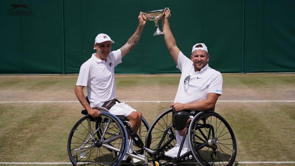 Dylan Alcott of Australia and Andy Lapthorne of Great Britain - Wimbledon 2019 Two male wheelchair tennis players holding a trophy on a grass court