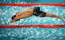 Swimmer starts a race from the start block jumping in the water.