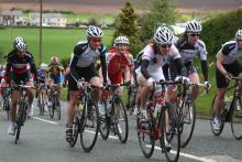 An athlete on a bike with other athlete