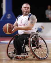 A picture of an athlete with a wheelchair playing basketball