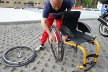 man changing wheelchair tyres