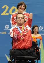 A picture of a man in an electric wheelchair celebrating his victory.