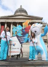 A picture of a young girl and an old woman posing for the London 2012 Torch Relay event