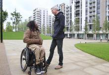 A picture of a man in a wheelchair and another man talking