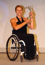A picture in a wheelchair posing with a reward