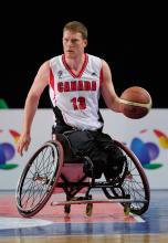 A picture of a man in wheelchair playing basketball