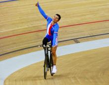 A picture of a man celebrating his victory on a bike