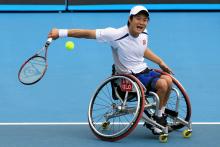 A picture of a man in a wheelchair playing tennis