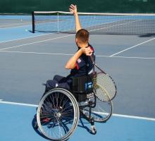 A picture of a man in a wheelchair playing tennis