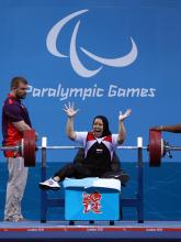 Fatma Omar raises her hands in celebration after winning her 4th consecutive Paralympic gold.